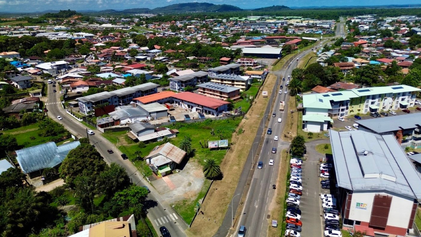 Vue aérienne d'un axe routier passant et de terrains en bord de voie à Cayenne