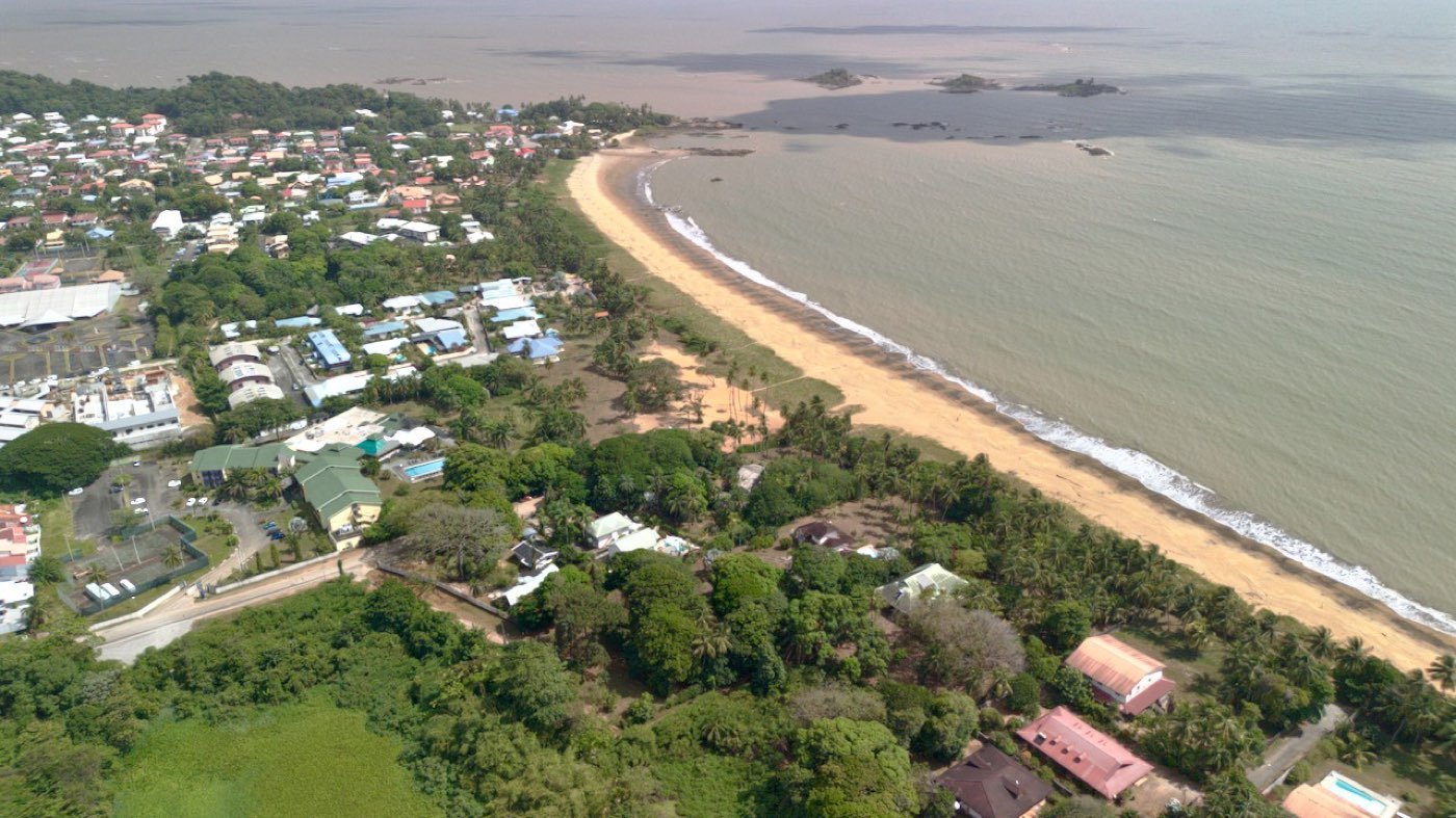 Vue aérienne d'une plage et d'un quartier résidentiel sur le littoral guyanais